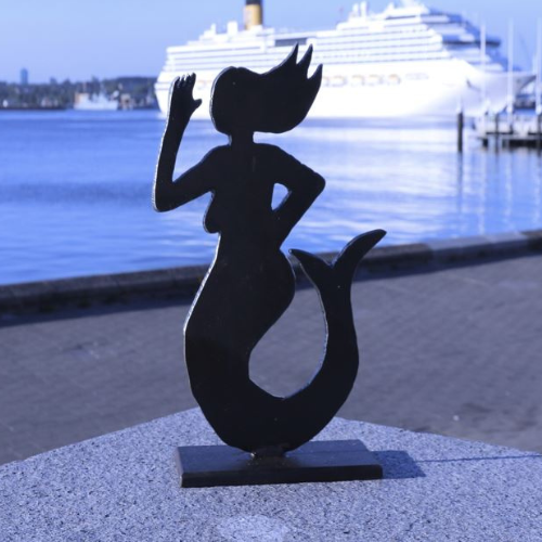 Emmi-Figur an der Kiellinie vor Kreuzfahrtschiff