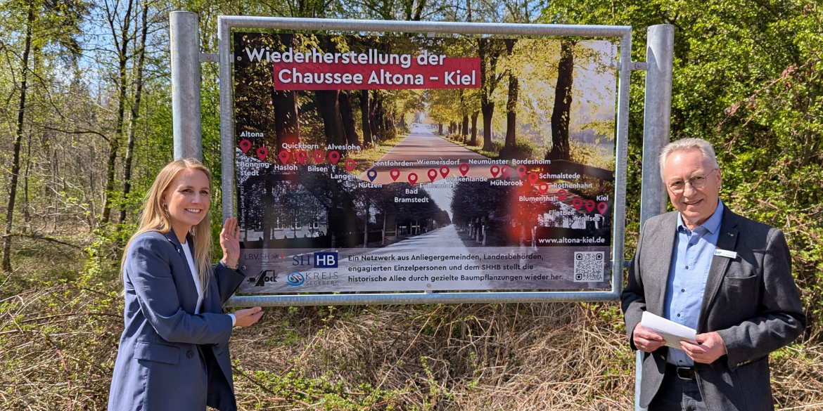 Staatssekretärin Carstens und SHHB-Präsident Peter Stoltenberg vor Schild