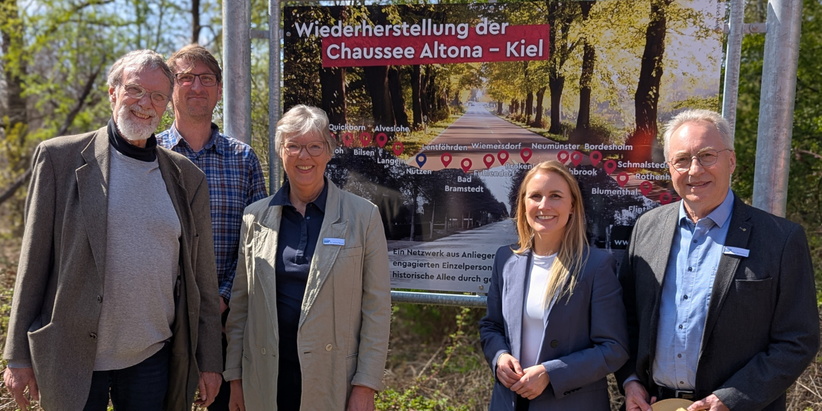 Fünf Personen vor Schild