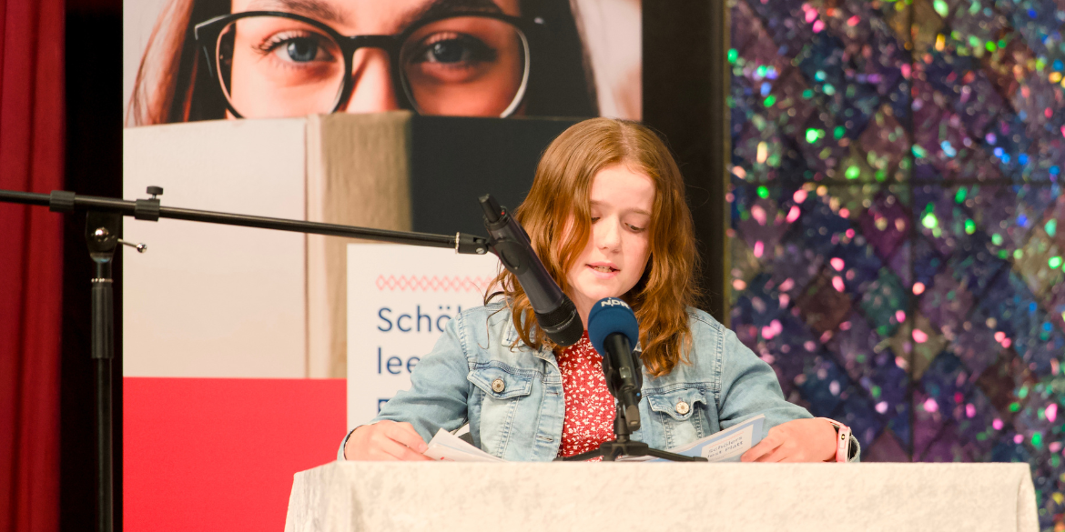 Mädchen liest auf Bühne