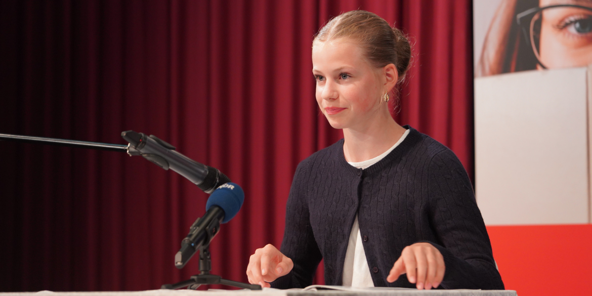 Mädchen liest auf Bühne