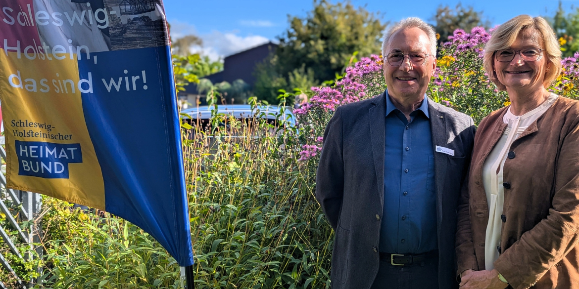 Zwei Personen vor Blütenhecke