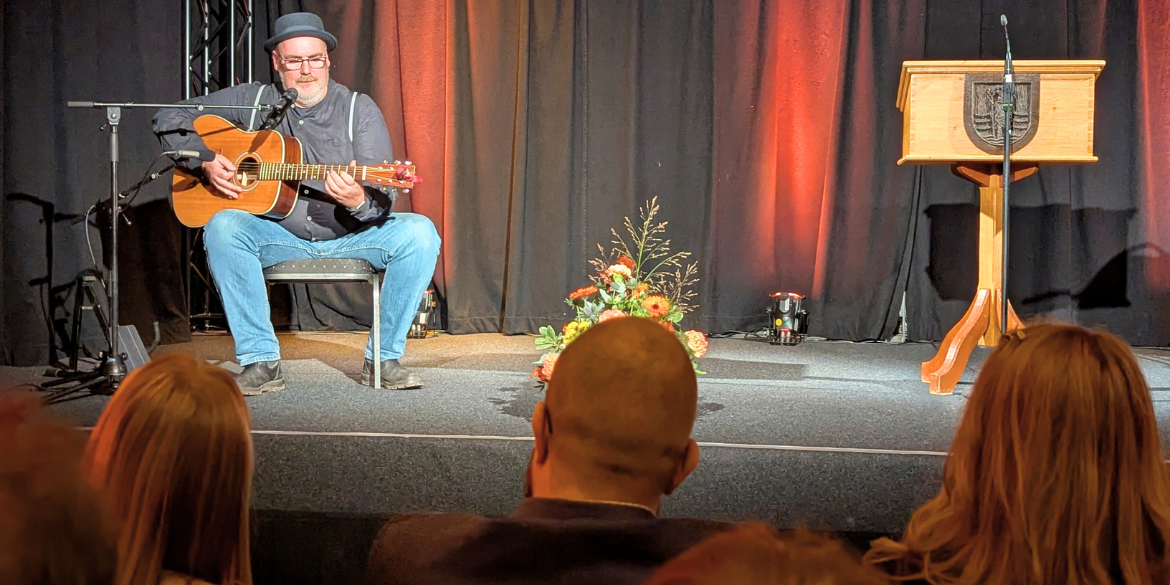 Gitarrist sitzt auf Bühne