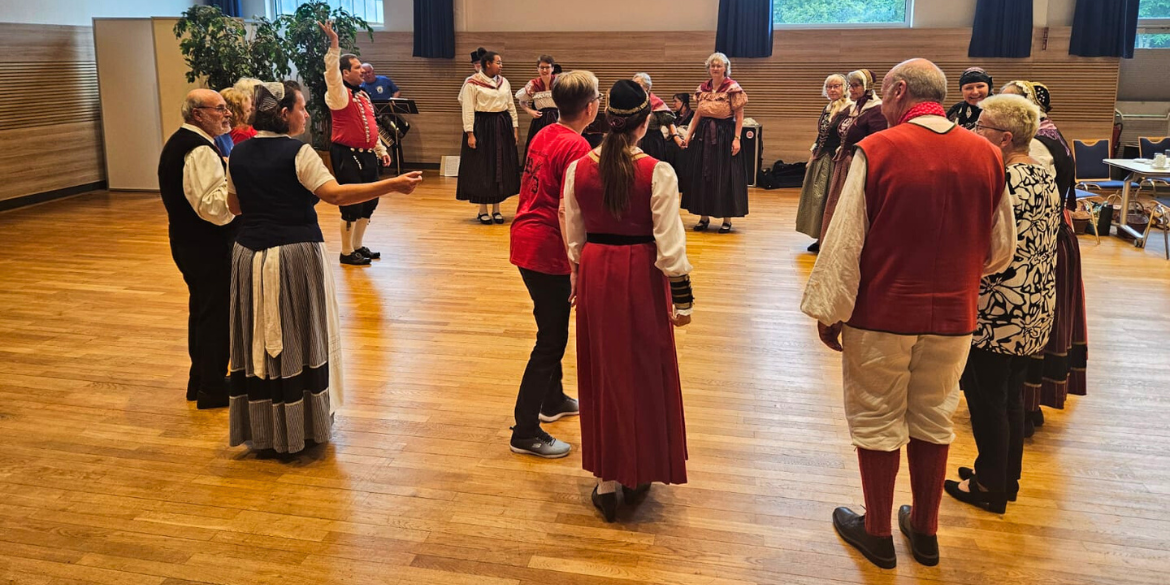 Tänzer*innen in Tracht stehen im Kreis