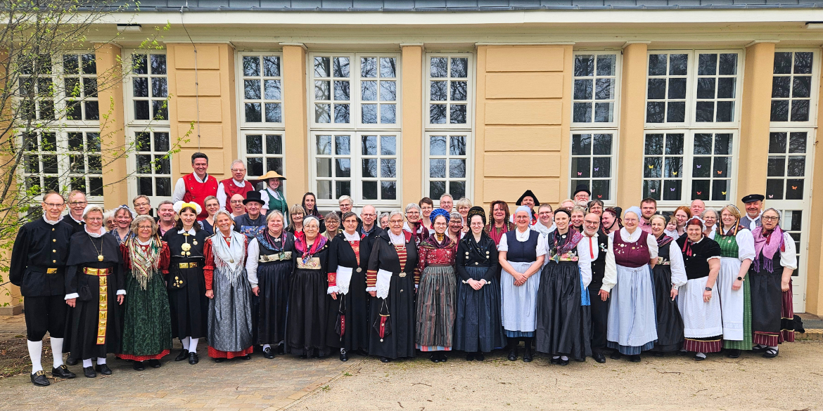 Knapp 60 Trachtenträger*innen vor dem Volkshaus Tungendorf