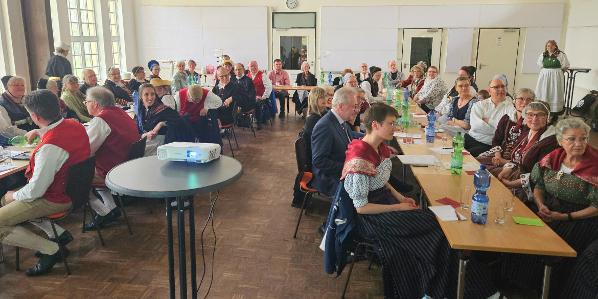 Viele Menschen an langer u-förmiger Tafel