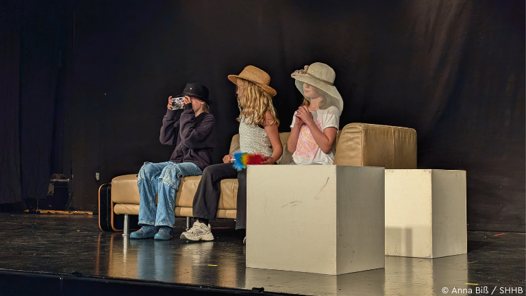 Drei Kinder spielen auf der Bühne Theater