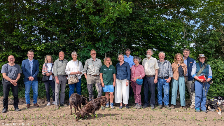 Gruppenbild vor einem grünen Knick
