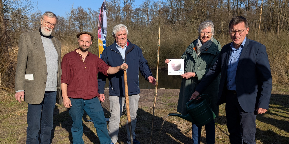 Personengruppe um jungen Baum