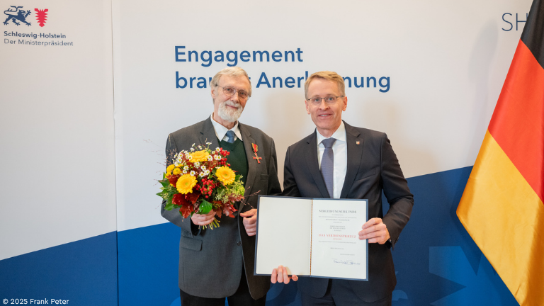 Holger Gerth und Daniel Günther vor Wand mit der Aufschrift "Engagement braucht Anerkennung"