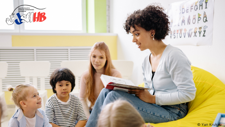 Frau liest Kindern ein Buch vor